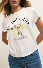Woman wearing a sea salt colored tee with lemon graphic and text La Dolce Vita The Sweet Life paired with blue jeans