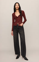 Woman wearing a deep red Velvet Rouge Albany Waffle Button Up Top by z supply with black jeans and boots