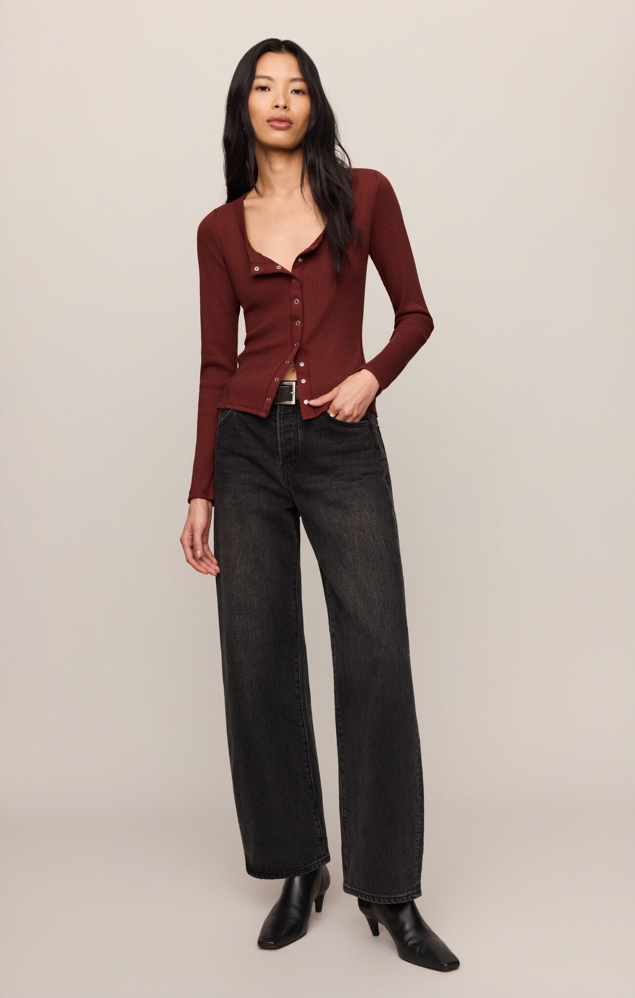 Woman wearing a deep red Velvet Rouge Albany Waffle Button Up Top by z supply with black jeans and boots