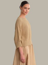 Model wearing a beige textured knit Chanterelle Sequoia Oversized Boxy Tee by 525 america, styled with a skirt.