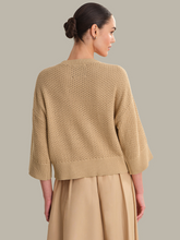 Model wearing a beige Chanterelle Sequoia Oversized Boxy Tee by 525 america shown from the back with textured knit design.