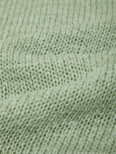 Close-up of knitted fabric texture in soft green from the Silt Green Faye Rolled Edge Sweater Tee by 525 america