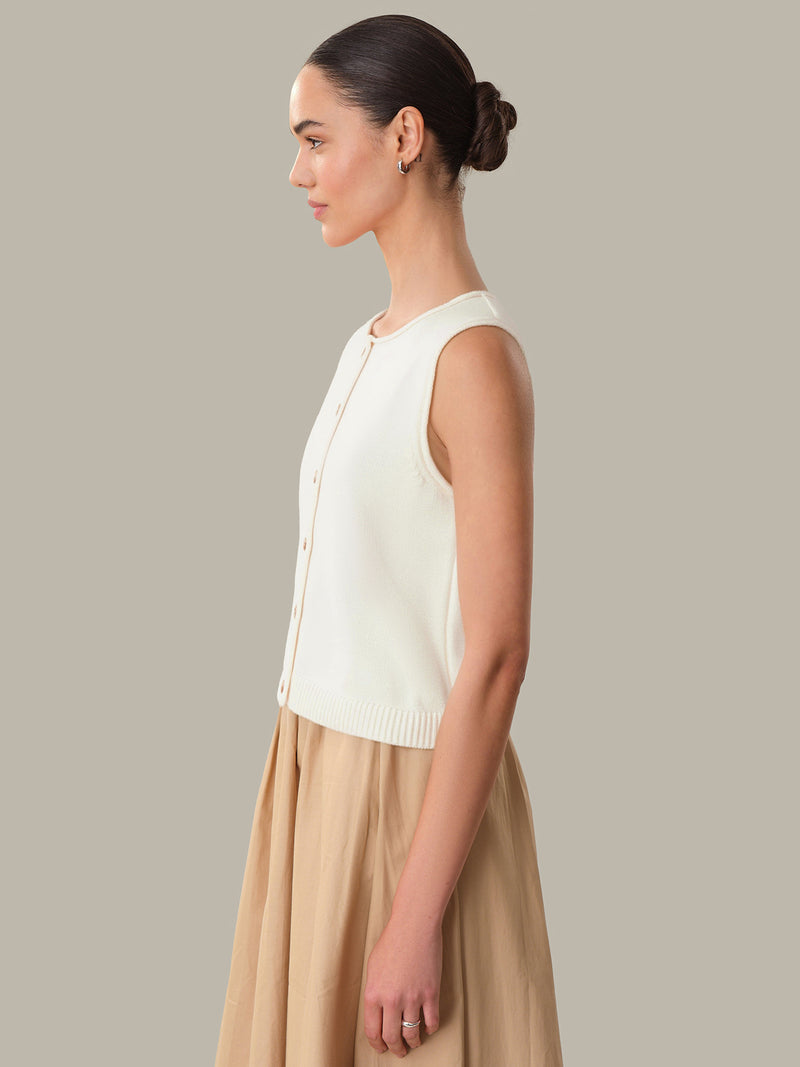 Side view of a woman wearing a Chalk Marianna Rolled Edge Button Front Tank by 525 america in light beige color