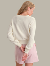 Woman seen from back wearing a soft cream Chalk Combo Bella Graphic Pullover by 525 america with long sleeves and ribbed cuffs