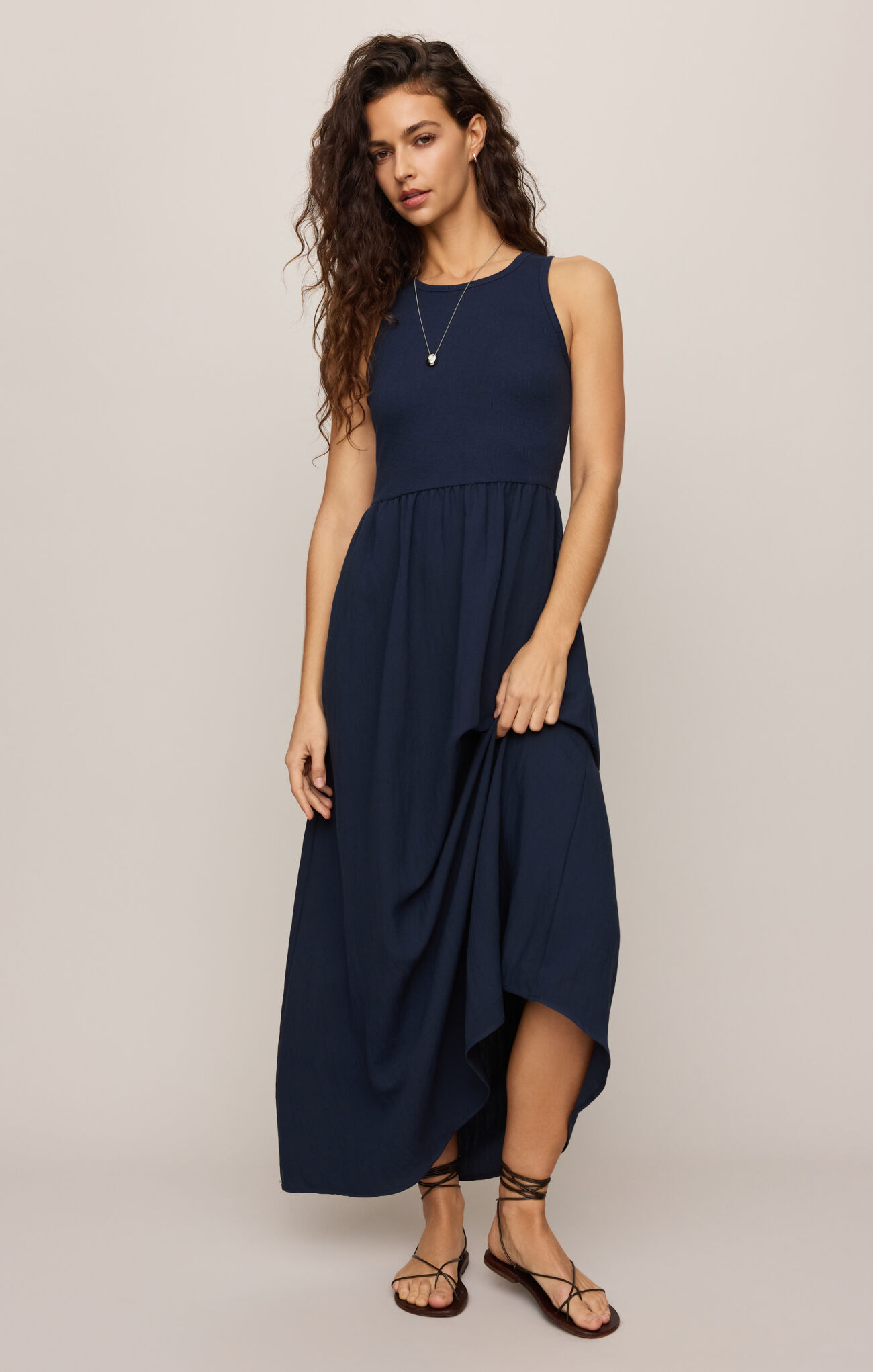 Woman wearing navy Eclipse Charlotte Midi Dress by z supply with sleeveless top and flowing skirt midi length
