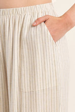 Close-up of hand in pocket of Light Beige Luxe Pants by Molly Bracken featuring subtle vertical stripes and elastic waistband