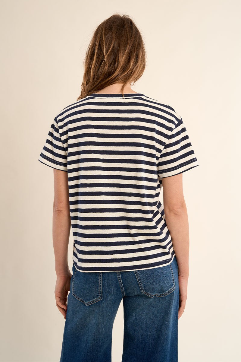 Back view of a woman wearing Navy Blue Stripe V-Neck Tee by Molly Bracken with horizontal navy stripes and short sleeves