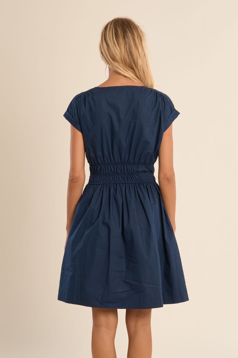 Back view of a woman wearing Navy Blue Harbor Dress by Molly Bracken with gathered waist and short sleeves