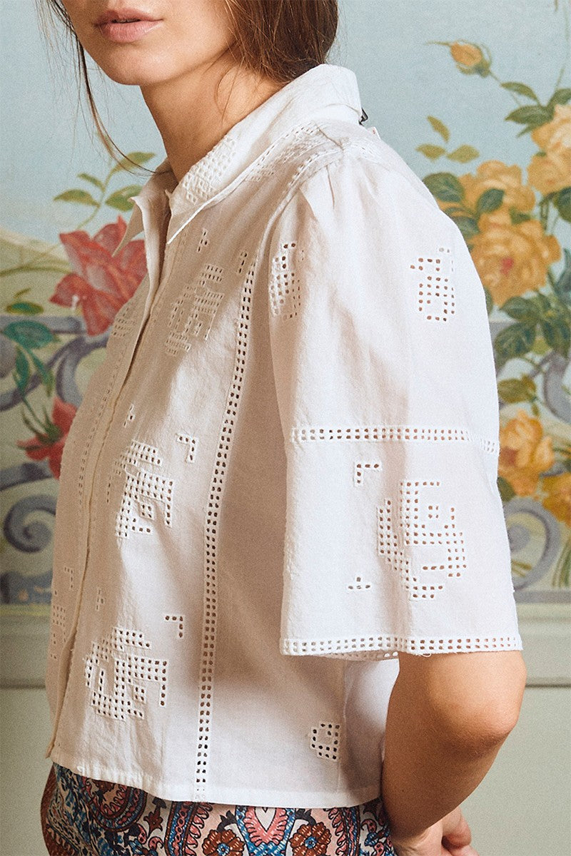 Close-up of a woman wearing OffWhite The Stella Shirt by Molly Bracken with delicate cut-out floral embroidery design