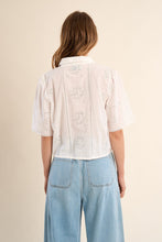 Back view of a woman wearing OffWhite The Stella Shirt by Molly Bracken with eyelet lace detail and light blue jeans