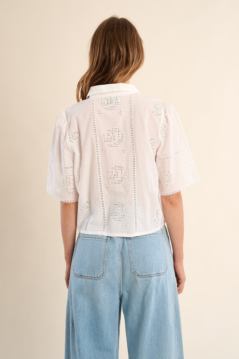 Back view of a woman wearing OffWhite The Stella Shirt by Molly Bracken with eyelet lace detail and light blue jeans