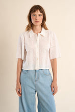 Woman wearing OffWhite The Stella Shirt by Molly Bracken, a short-sleeve white button-up with cutout patterns.
