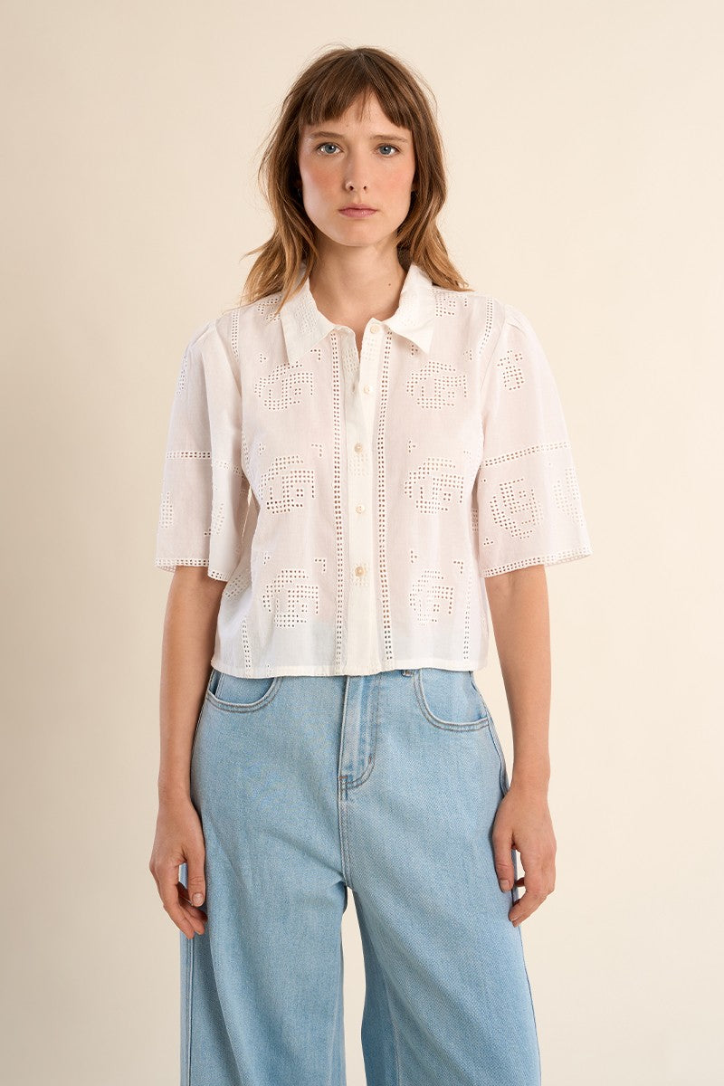 Woman wearing OffWhite The Stella Shirt by Molly Bracken, a short-sleeve white button-up with cutout patterns.