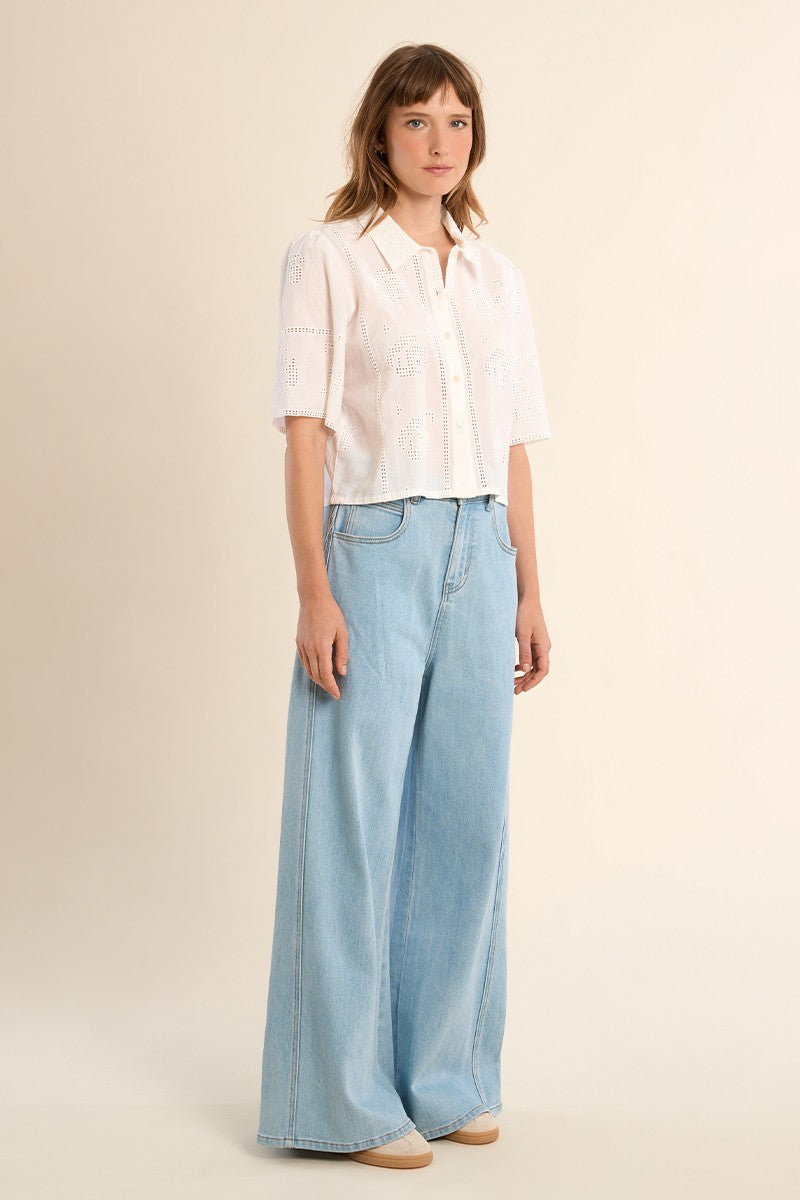 Woman wearing OffWhite The Stella Shirt by Molly Bracken paired with wide leg light denim jeans and neutral shoes.