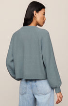 Woman wearing a blue Soft Succulent Coming Up Sweater by z supply shown from the back with long sleeves and ribbed hem