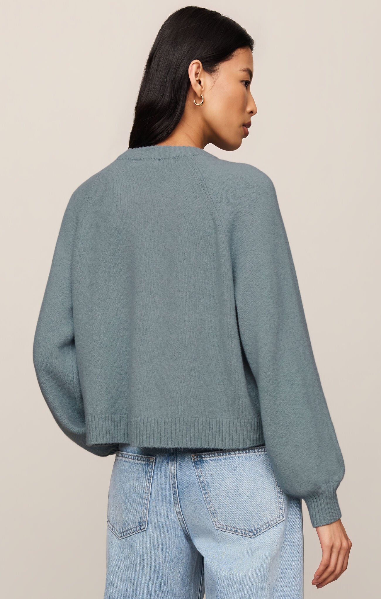 Woman wearing a blue Soft Succulent Coming Up Sweater by z supply shown from the back with long sleeves and ribbed hem