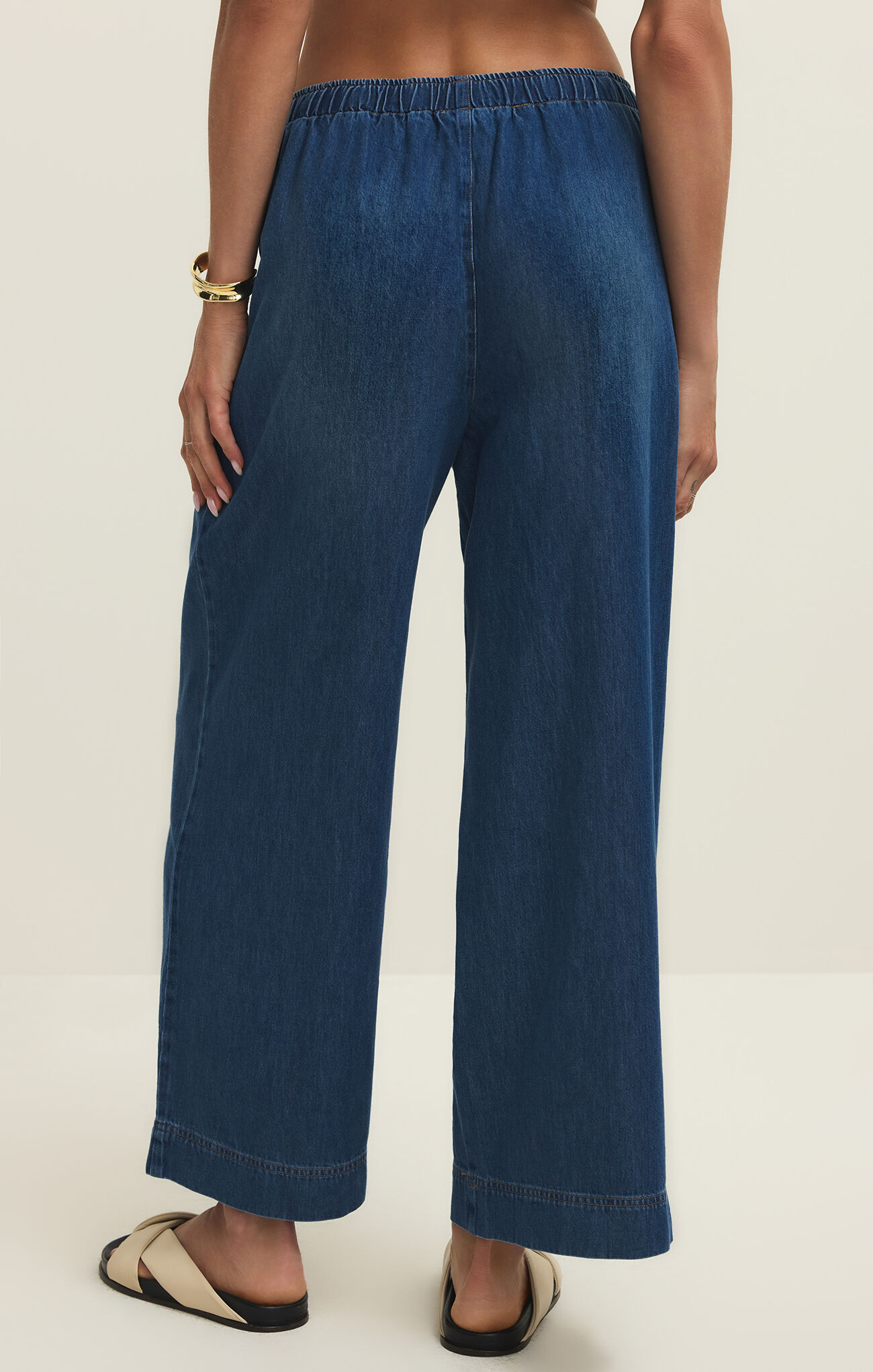 Back view of z supply Deep Water Daycation Denim Utility Pant in deep blue with elastic waistband and wide leg design