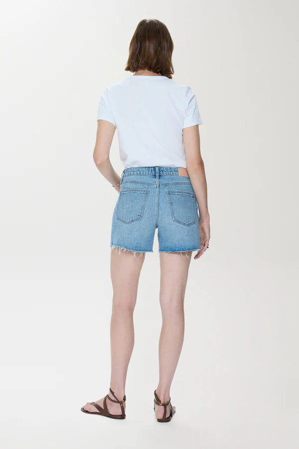 Back view of woman wearing Pistola Kennedy Short denim shorts with frayed hems and a white t-shirt