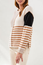 Woman wearing Tribal Multi Stripe Textured Boat Neck Sweater in beige, black, and brown stripes with contrast stitching detail.
