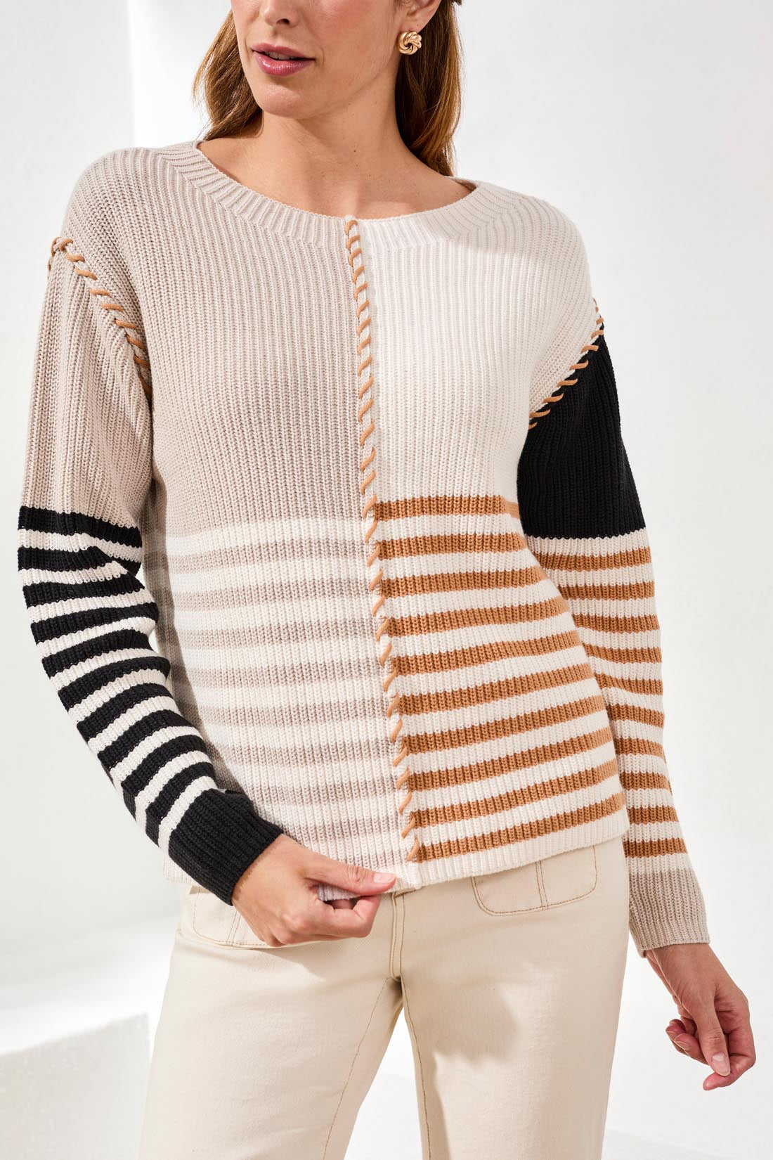 Woman wearing Tribal Multi Stripe Textured Boat Neck Sweater in beige, black, and brown stripes with textured knit details