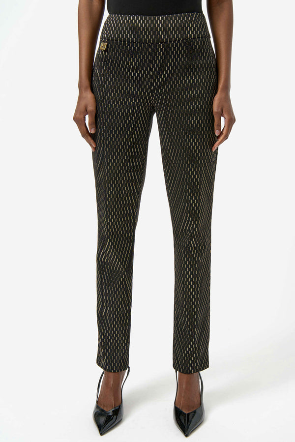 Person wearing black slim pants with subtle gold dotted foil print and black pointed heels standing facing forward