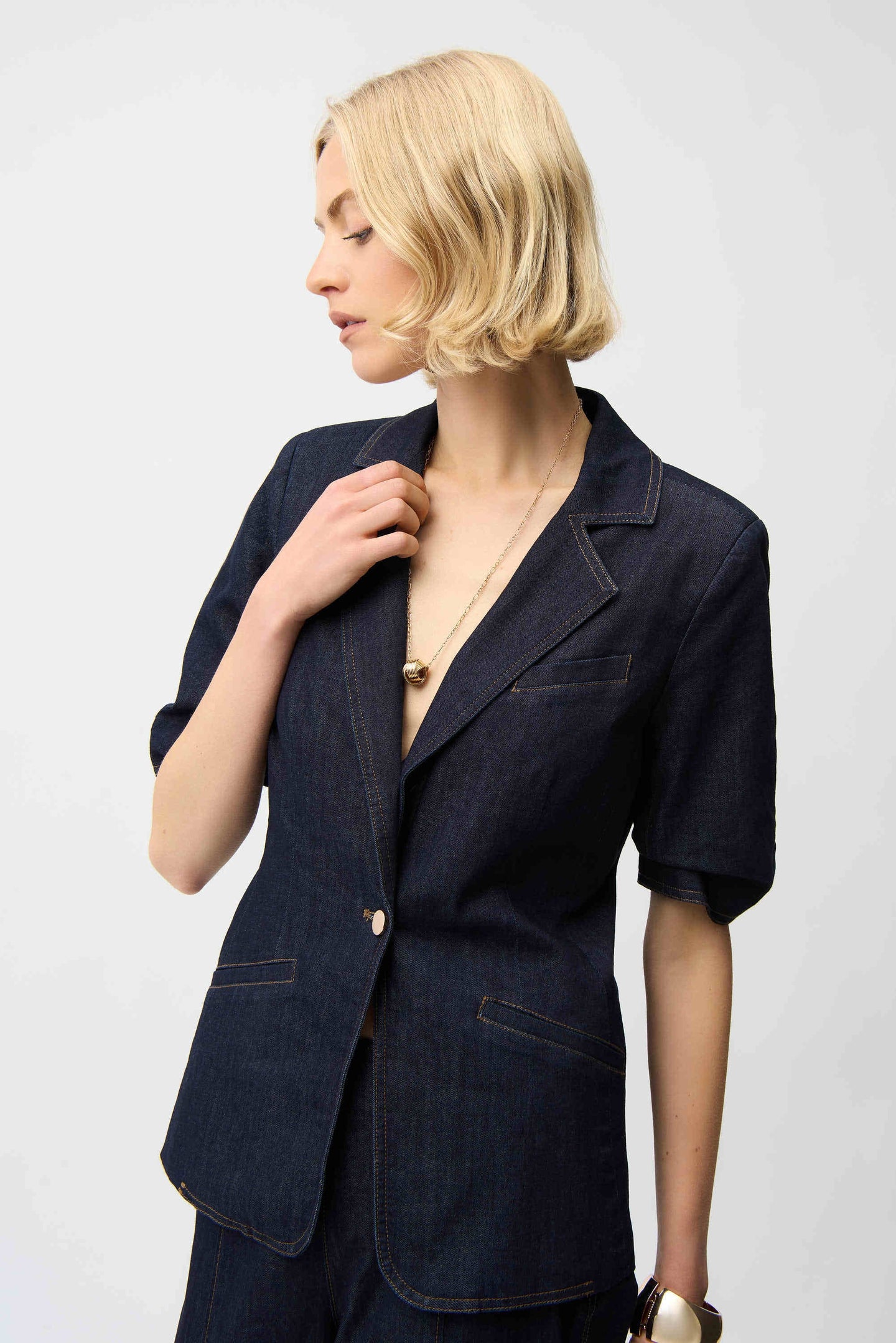 Model wearing Joseph Ribkoff Dark Blue Denim Fitted Blazer with short sleeves and gold accessories by JOSEPH Ribkoff