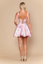 Back view of a woman wearing a pink floral jacquard Jacquard Homecoming Dress by Ed Young with lace-up back detail.