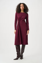 Woman wearing a burgundy long sleeve dress with a gathered waist and tall brown boots