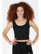 Woman wearing black Rib Knit Scoop Neck Tank by angie with curly hair and hands on hips against white background