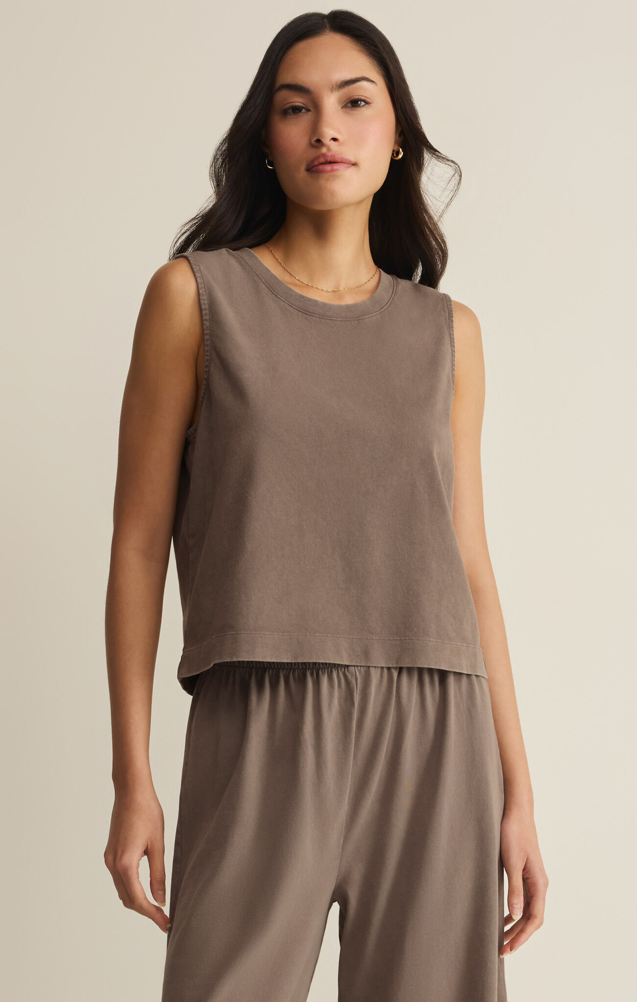 Woman wearing Perfectly Taupe Sloan Jersey Muscle Tank by z supply styled with matching relaxed pants in neutral background