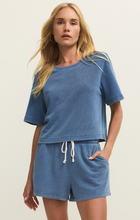 Woman wearing Calypso Blue Indigo Curran Knit Denim Sweatshirt by z supply with relaxed fit and soft denim knit texture