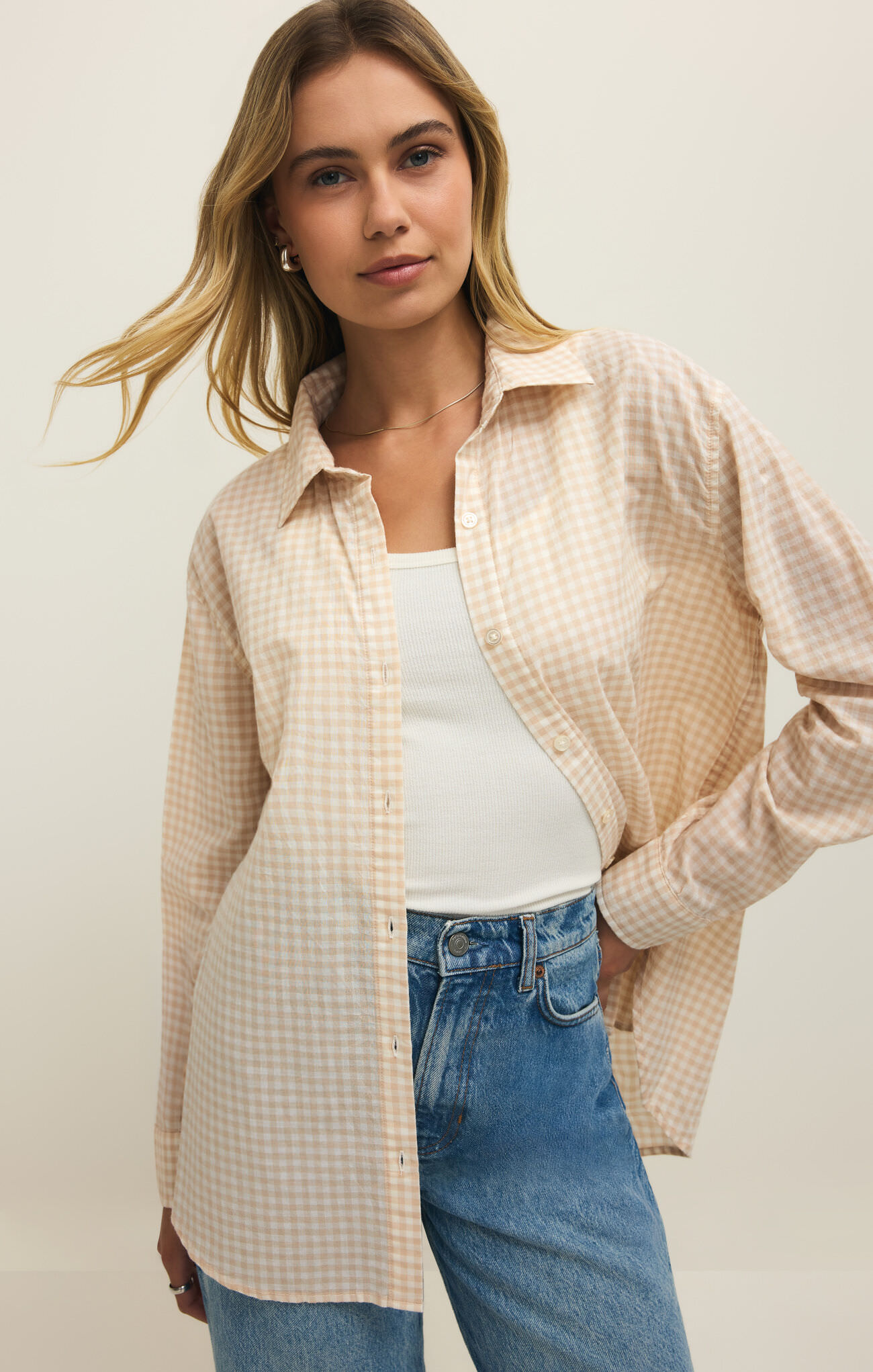 Woman wearing z supply Parchment Seaport Button Up Top in soft gingham pattern paired with casual blue jeans and white tank top