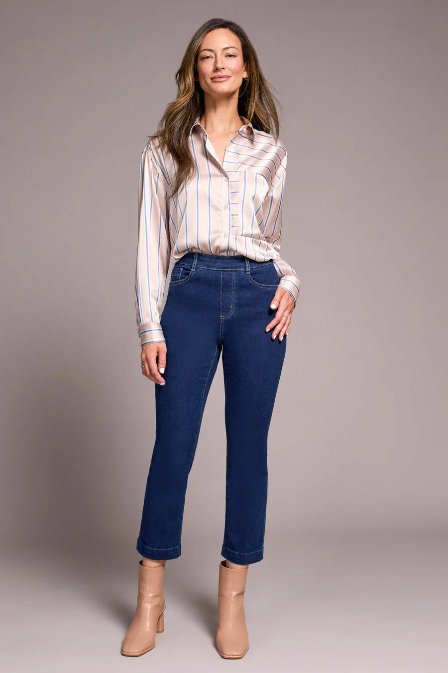 Woman wearing Tribal Audrey Pull-On Crop Straight Jeans with Front Crease styled with a striped blouse and beige ankle boots