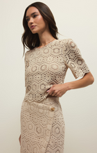 Model wearing a beige intricate crochet pattern Natural Raquel Lace Top by z supply with short sleeves and scalloped edges