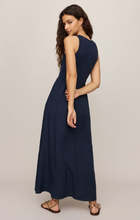 Model wearing navy blue Eclipse Charlotte Midi Dress by z supply with sleeveless design and flowing skirt shown from back angle