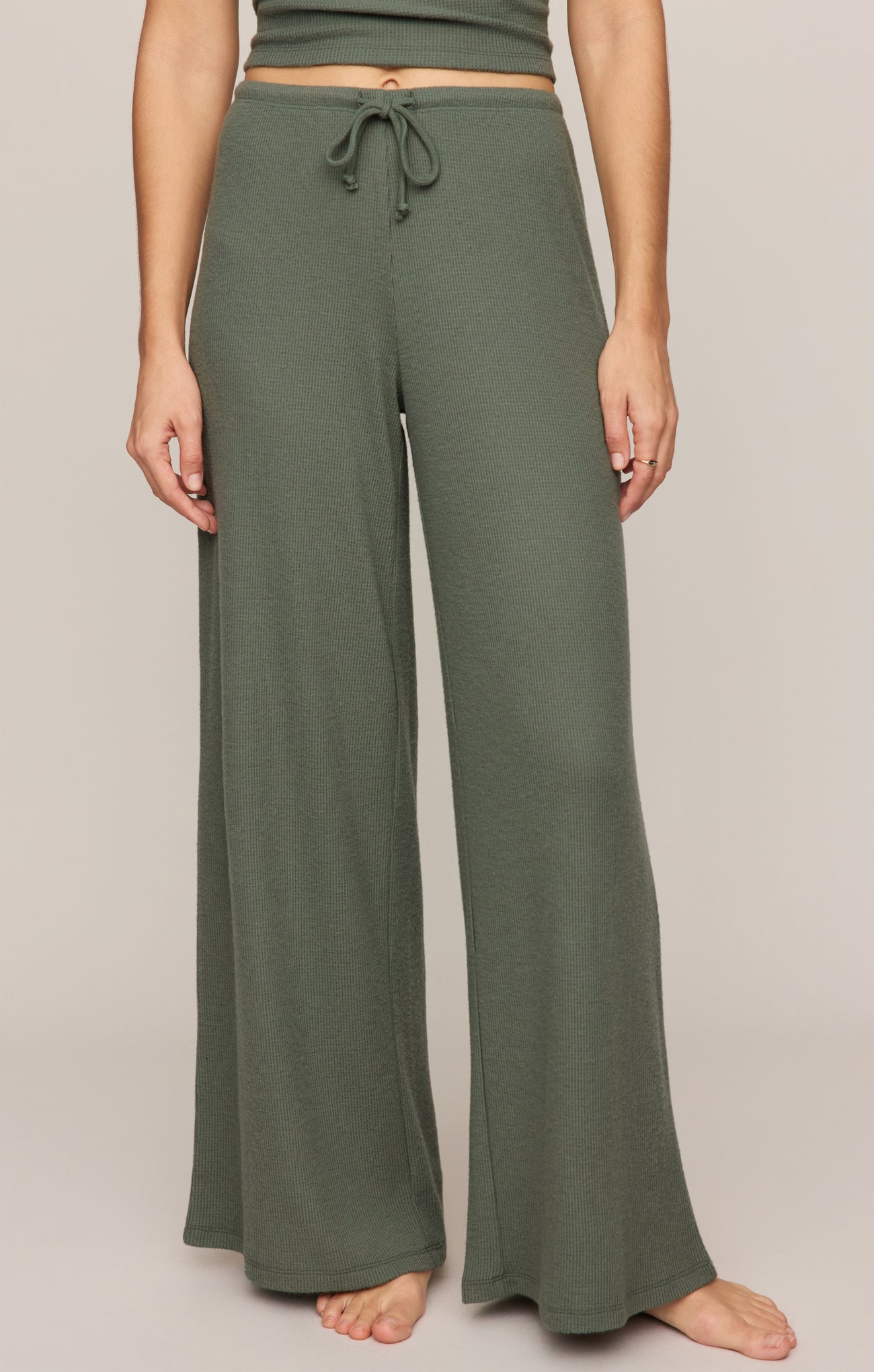 Front view of olive green Monstera Waffle Pant by z supply with wide legs and drawstring waist on model