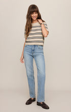 Woman wearing Light Oatmeal Heather Gatewood Stripe Sweater by z supply with light blue jeans and dark loafers