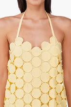 Close-up of a halter neck Butter Yellow Opal Circle Radiance Dress by America & Beyond with textured circular fabric details