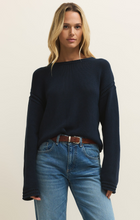 Woman wearing a navy Eclipse Bellami Sweater by z supply with relaxed fit and long sleeves paired with jeans
