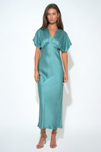 Model wearing Adelyn Rae Jade Charlotte Flutter Sleeve Midi Dress in teal satin with v-neck and flutter sleeves