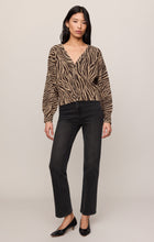 Woman wearing a zebra print Dark Chocolate All The Wild Cardigan by z supply with black jeans and heels.