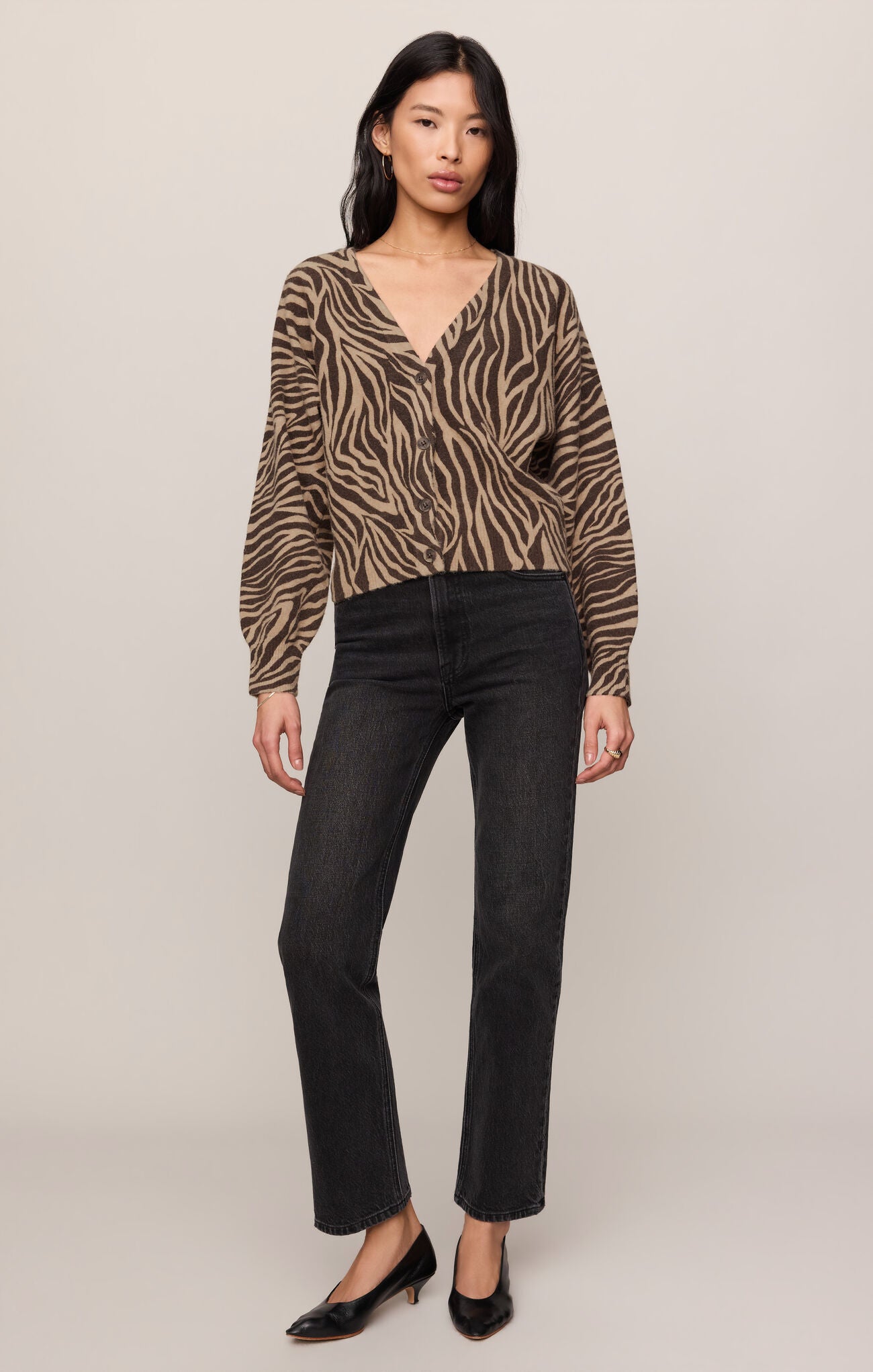 Woman wearing a zebra print Dark Chocolate All The Wild Cardigan by z supply with black jeans and heels.