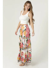 Woman wearing angie Floral Wide Leg Pants with vibrant pink and yellow floral print paired with white crop top
