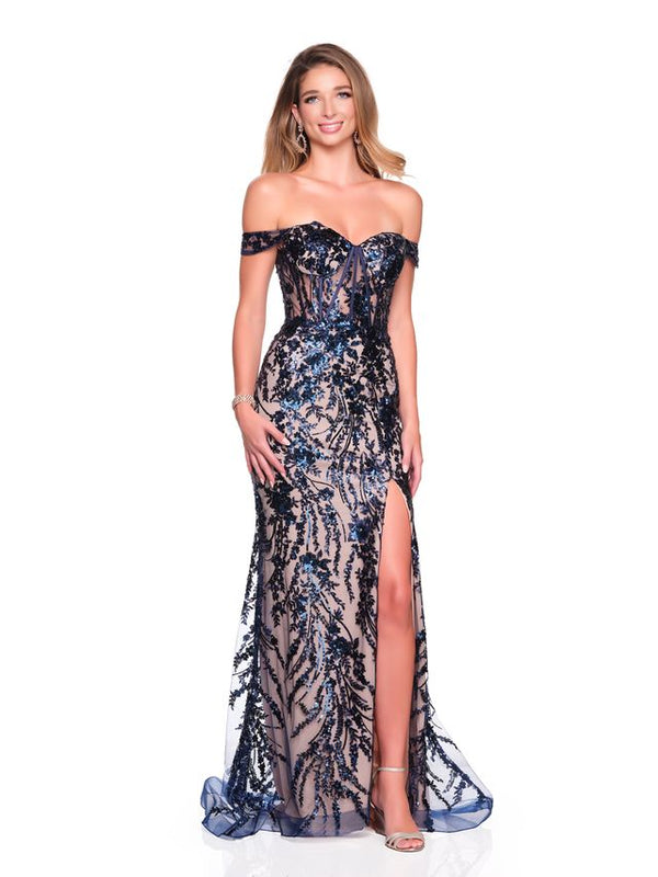 Woman with long blonde hair wearing a navy nude off-shoulder sequin prom dress with a thigh-high slit standing against a white background