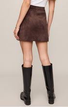 Back view of a model wearing the Dark Chocolate Perri Suede Mini Skirt by z supply with black knee-high boots.