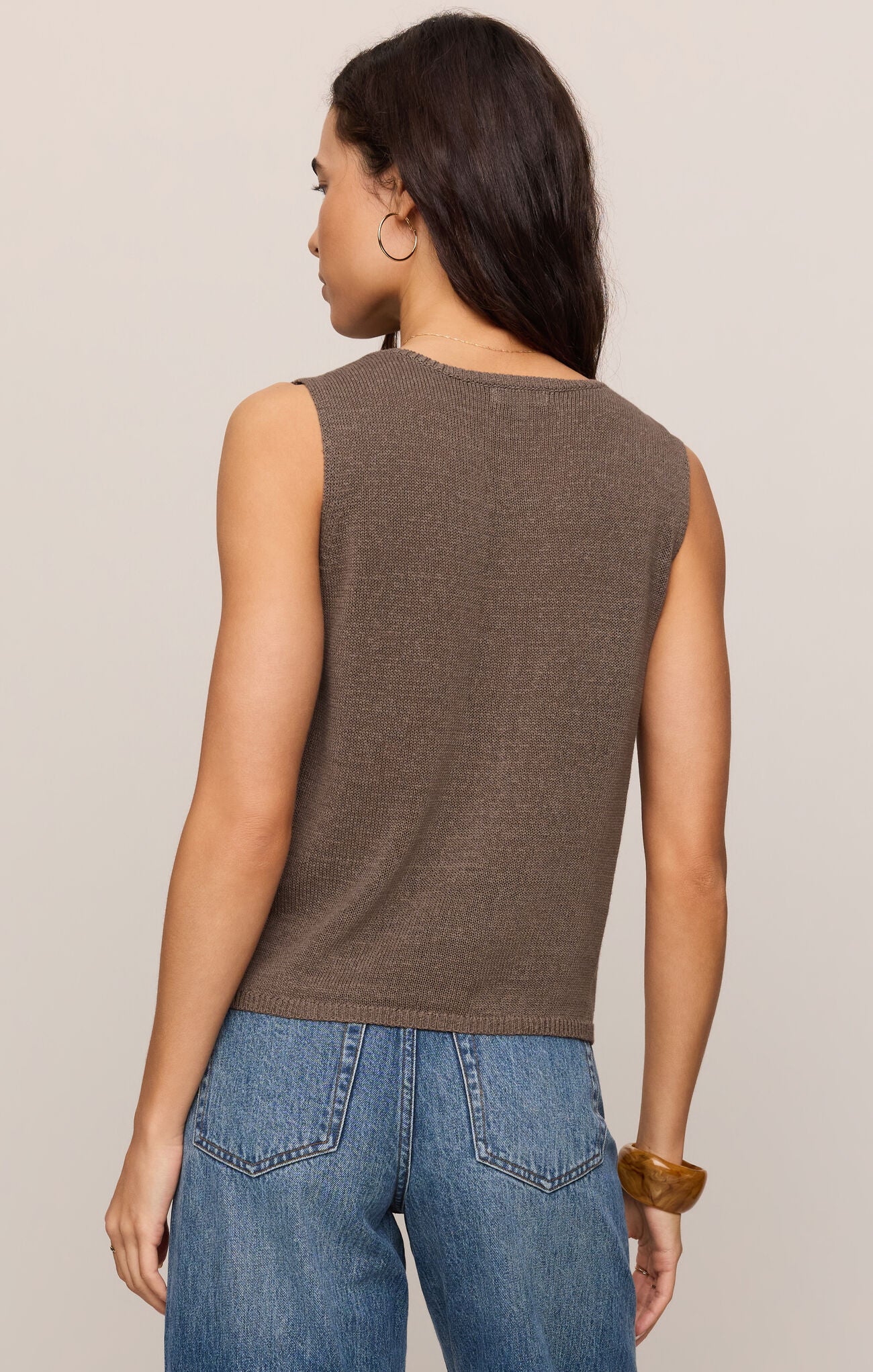 Woman wearing a brown Pebble Coast Syd Sweater Vest by z supply paired with blue jeans, shown from the back.