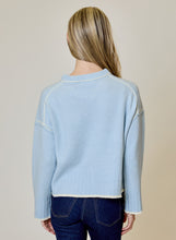 Blue Echo Sweater by design history shown from the back on a model in light blue knitwear