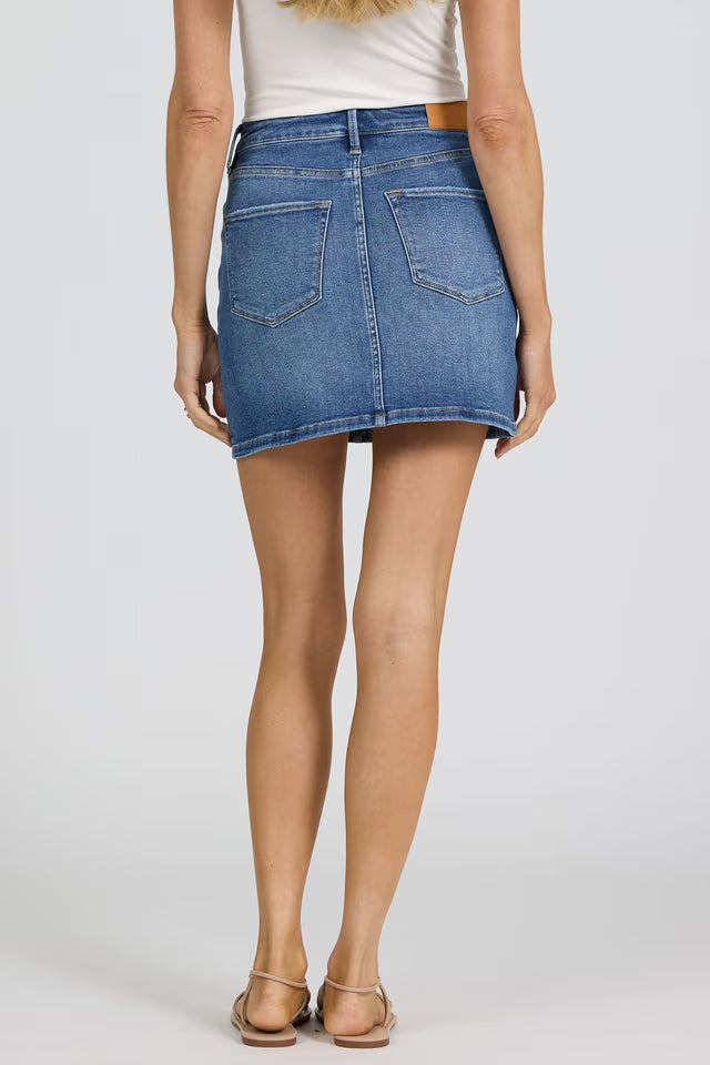 Rear view of a woman wearing Dear John Quinn Skirt in classic blue denim with back pockets and sandals