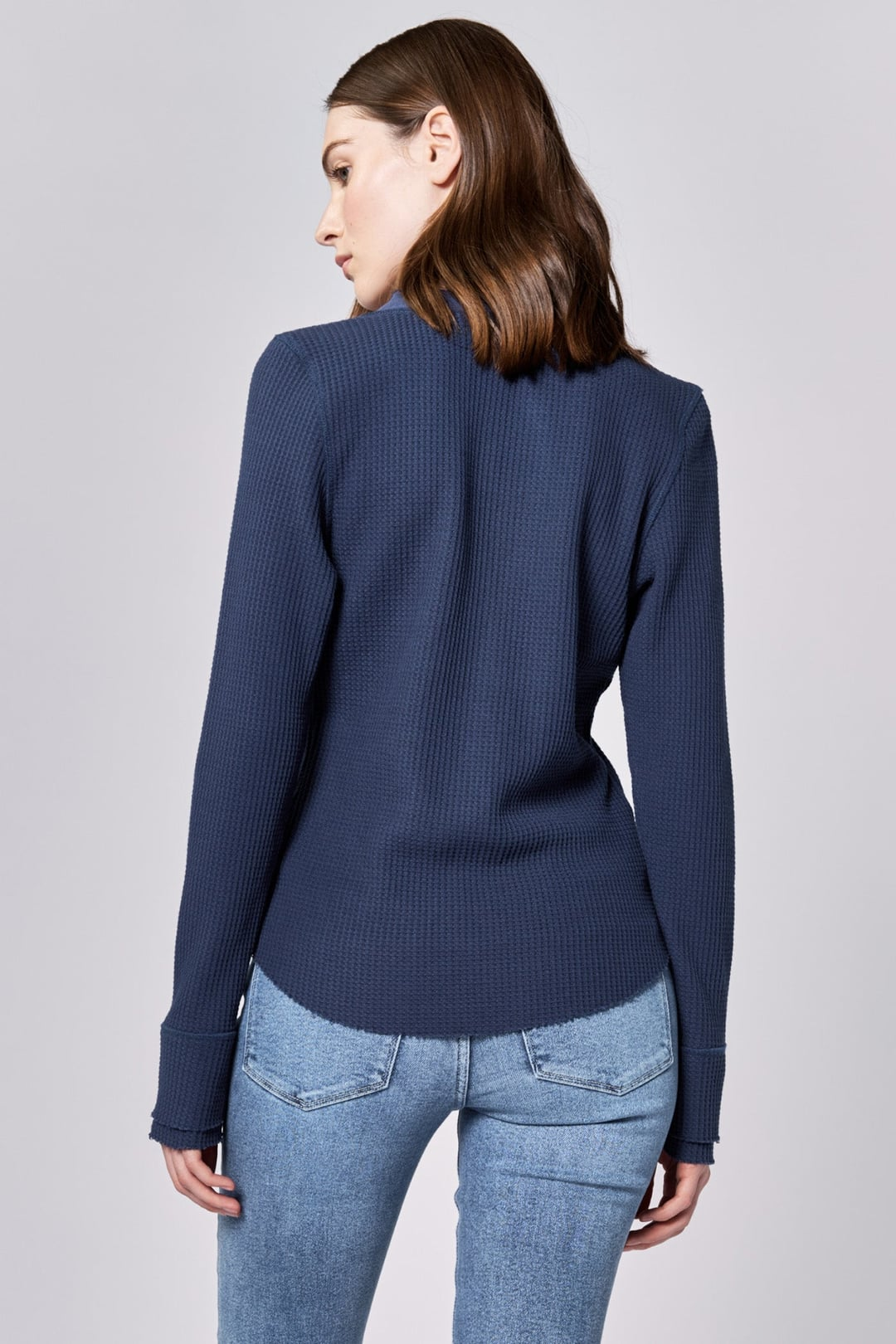 Back view of model wearing Black Iris Luna Top by dear john, featuring long sleeves and textured fabric in navy blue