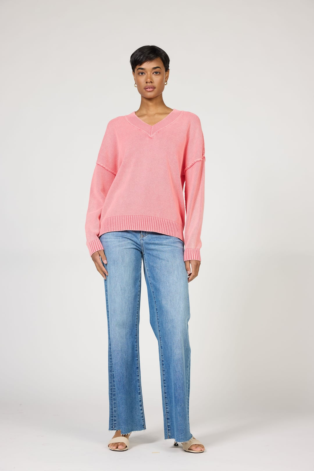Model wearing a relaxed fit Grenadine Vienna Sweater by dear john with acid wash detail and v-neck design